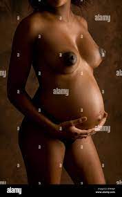 Nackt nackte junge schwarze Afro-karibische Frau schwanger, halten ihre  geschwollenen dicken Bauch Stockfotografie - Alamy