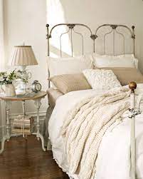 These Warm Paint Color Ideas Will Make Your Home Feel Extra Cozy Cream And White Bedroom White Bedroom Design Iron Bed