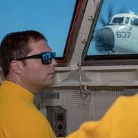 Sergeant Tim Hoye, instructor, prepares to push blindfolded SENIOR AIRMAN  Kyle Stanbro from a platform into a swimming pool during a US Air Force  Ranger Preparation Training session. Stanbro is carrying an