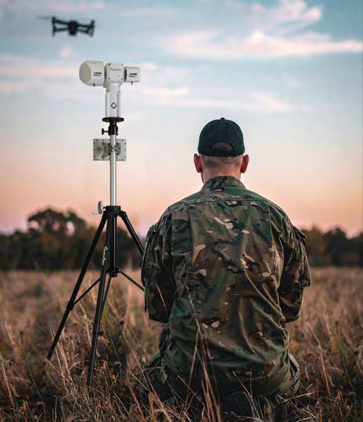 A military-grade mobile radar unit deployed in a desert environment during field exercises.