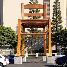 Large wooden deck chair on the side of a road has a seat large enough to accommodate several people, but no easy way to get up to it. Giant Wooden Chair In Los Angeles Ca