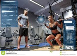 man and woman with bar flexing muscles in gym stock image