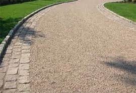 Spray a hot liquid asphalt emulsion on the surface, then immediately spread a uniform layer of stone chips on top and compact it with an industrial roller. Tar And Chip Driveway This Has An Upscale Look With The Cobblestone Edging The Raised Curbing Will Work Great Stone Driveway Gravel Driveway Asphalt Driveway