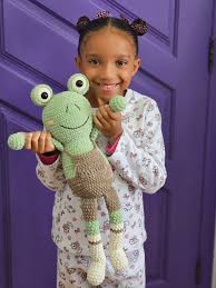 Bebê abraçando um amigurumi de bichinho em tons pastéis