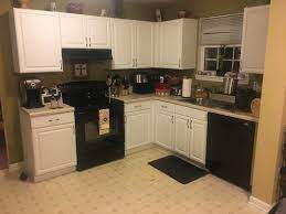 The countertop is black with gray and beige specks and the backsplash has a slight gray swirl. What Color Walls In Kitchen With White Cabinets And Black Appliances