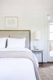 The tapered, slightly turned legs are fluted, a reference to classic columns. Black Geometric Wall With Black Cane Headboard Transitional Bathroom