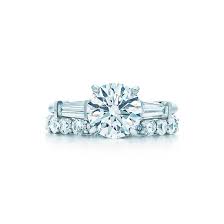 Tapered Baguette Side Stones Draw The Eye Toward The Remarkable Round Brilliant Center Tiffany Engagement Ring Baguette Engagement Ring Engagement Rings Round