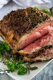 A 5 Pound Prime Rib Roast Served On A White Platter With Fresh Herbs Underneath With A Few Slice Cooking Prime Rib Roast Boneless Prime Rib Recipe Rib Recipes