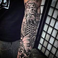 The koi fish, in red and black ink, rests vertically on a background of a colured flower with a distinct blue highlight and grayscale floral patterns amid patterns of parting waves. Top 47 Koi Dragon Tattoo Ideas 2021 Inspiration Guide