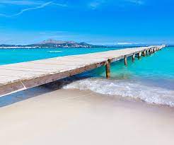 Long White Sandy Beaches Shallow Clear Waters And A Gentle Relaxing Breeze At Platja De Muro In Alcudia Holidays In Europe Mallorca Beaches Places To Travel