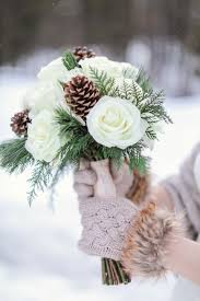 Combine with fur and velvet accents. Fur Trimmed Gloves Of The Bride Hold Her Winter Elopement Bouquet With Pinecones And Pine Winter Wedding Bouquet Winter Bridal Bouquets Winter Wedding Flowers