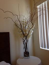 Silk Ivory Orchids With Large Branches In A Tall Rectangular Vase With Filler Stones This Arrangement Sits Tall Vase Decor Large Vases Decor Foyer Decorating