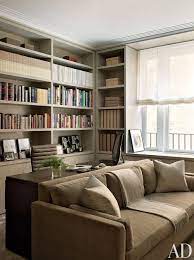 In A Cozy New York Library The Sofa Is Covered In A Neutral Velvet Living Room Office Combo Living Room Office Guest Room Office