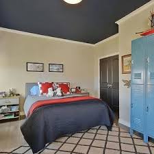 The room has a stylish and comfy bed set along with glass windows. Artistic Designs For Living Boy S Rooms Beige Walls Beige Wall Color Gray Washed Hardwood Floors Li Blue Living Room Blue Living Room Color Blue Ceiling