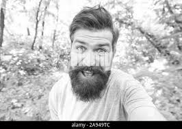 Go wild. Hair care male beauty. Summer fun. Bearded guy in park forest.  Bearded hipster. Crazy bearded man in natural environment. Hipster with  long beard emotional face close up nature background Stock