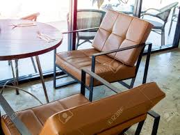 It is also very comfortable it features a solid wood leg with plastic glides making it reliable as long as the durability is concerned. Black Metal Frame And Tan Leather Armchair Retro Style And Round Stock Photo Picture And Royalty Free Image Image 128699739