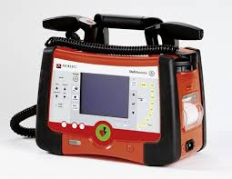 Paddles of a defibrillator producing an electric discharge on an image of the heart. What Is A Defibrillator