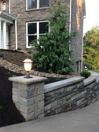 Integrated Stone Pillar With Post Lamp Lighting As Part Of A Retaining Wall Custom Landscape Design Landscaping Retaining Walls Front Yard Landscaping Design