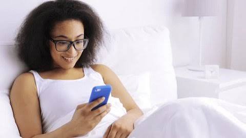 Black Woman Smiling Texting On Bed Stock Photo 221861632 | Shutterstock