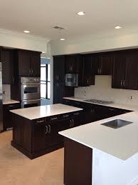 White Quartz Countertops And Brown Dark Cabinets Http Www Stoneandquartzsurfaces C Dark Brown Kitchen Cabinets Dark Kitchen Cabinets Brown Kitchen Cabinets
