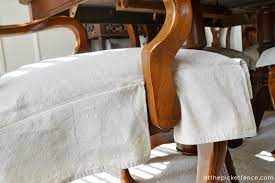 It is upholstered in a yellow/green textured poly linen. Drop Cloth Chair Skirts