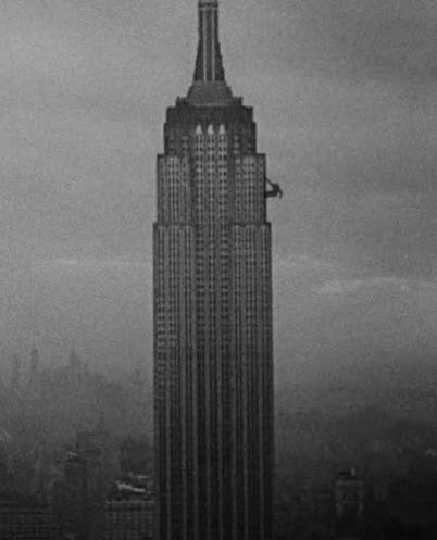 King Kong climbing the empire state building from a birds eye view in the style of Ansel Adams --style raw