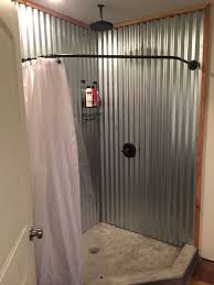 The aluminum appeared to be screwed to the wall using exposed metal roofing screws (the kind with rubber washers), and it met a tiled floor/curb at the bottom. Rustic Corrugated Metal Bathroom Novocom Top