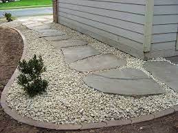 Buy a big bag of sand at the home and garden center and spread it out to help level out the stone — and then simply flip over the stone and put it back in place. Cover French Drain Path Like This With Gravel Rock Set In Big Stepping Stones And Line With Pavers Or Edg Stone Landscaping Landscape Edging Landscape Bricks