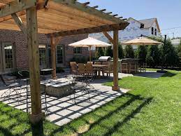 A pergola covering the outdoor fireplace or fire pit in the backyard offers freedom from the normal routine and the delight of a camping atmosphere while enjoying the conveniences and cleanliness of home. Multi Patio Space With Pergola Outdoor Kitchen With Pub Seating Glenview Il Northbrook Decks Pergolas Stone Paver Patios