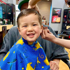 Kai got his first official haircut at Sport Clips Haircuts of Rancho  Bernardo Town Center, and if that smile is any indication, we'll say that  it was a home run!