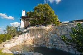 Grotto Waterfall From Negative Edge Pool In The Texas Hill Country Mexican White Stone Pool Builders Swimming Pool Builder Luxury Swimming Pools