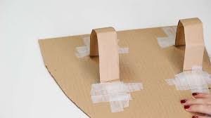 After the paint and glue have dried, take a strip of cardboard about 20cm x 7cm, and tape one end to the back of the shield. How To Make A Cardboard Shield English Heritage