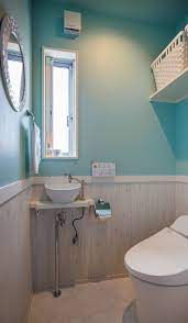 テーマはカリフォルニア風 ライトブルーのクロスに木目調のホワイトの腰壁が トイレを爽やかな印象に トイレ 壁紙 おしゃれ 西海岸 インテリア トイレ トイレ インテリア