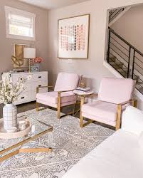 The walls are a pristine white while the furniture is black. Living Room Design Blush Chairs White And Gold Living Room Brass Accents Feminine Chic Decor Just A Tina Bit
