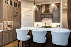 White farmhouse kitchen cabinets contrasts with medium tone wood countertop and frame. Brown Stained Kitchen Cabinets With White Quartz Countertop Country Kitchen