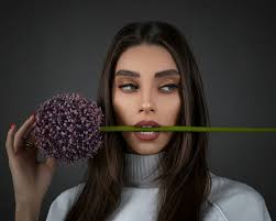 Woman in white shirt holding pink flower photo