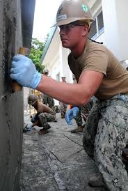 Steelworker 3rd Class Daniel Buskeness, from Mariposa, Calif., levels wet  concrete walls