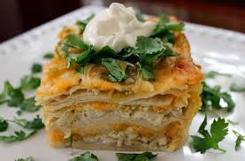 Cook the onions and green chiles in a large skillet to begin making the sauce for this casserole. Foodista Easy Dinner Recipe Cheesy 3 Layer Chicken And Green Chile Enchilada Casserole