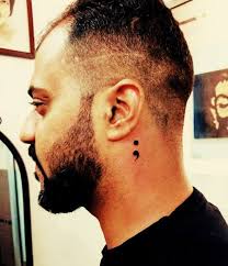 Semicolon tattoo, pictured behind ear. Facebook