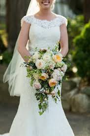 Orange unique roses are accented with hypericum berries and lemon leaves in this lively bouquet. Bridal Bouquets Cedar Grove Gardens