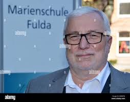 Fulda, Germany. 25th Feb, 2019. Teacher Peter Bach uses a document camera  to project a document onto a screen. On the wall there is a mobile phone  garage where the students deposit