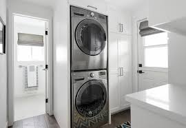 Small White Laundry Room Features Floor To Ceiling Cabinets Placed Next To A Stacked Washer And Laundry Room Storage Laundry Room Storage Shelves Laundry Room