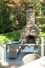 In addition to providing a splash of personality located on the outside edge of a covered patio, this striking stone fireplace warms an intimate seating arrangement. Creative Outdoor Fireplace Designs And Ideas