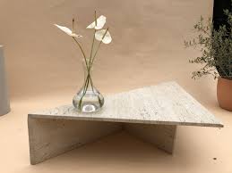 Triangle coffee table concrete with fiberglass as reinforcement, the thickness is only 3/4 and weighed about 80 lbs. Travertine Triangle Coffee Table Curated Spaces