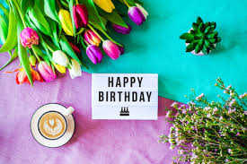 La base è un cartoncino color arancio sul quale ho incollato una carta a sfondo lilla (con all'interno, uno spazio in carta verde chiaro per il vostro messaggio e un fiore in cartoncino arancio. Immagini Stock Girato Dall Alto Come Flatlay Con Auguri Di Buon Compleanno Scritto Su Scatola Luminosa Con Caffe E Fiori E Tulipani Colorati Image 96329925