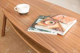 If you have access to an old door or window, repurpose it as a table top for a rustic coffee table. Two Magazines And Empty Coffee Mug On The Wooden Table Real Photo Stock Photo Picture And Royalty Free Image Image 111119868