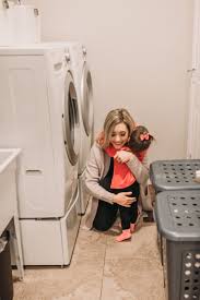 Bits Of Bri Blog Brianna K In Her Laundry Room Hugging Presley In Front Of Her Washer And Dryer After Sharing 5 Easy Laundry Hacks An Laundry Hacks Hang Dry Clothes Kid Laundry