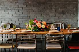 The table is also easy to clean thanks to its brushed surface. Modern Dining Table With Tropical Centerpiece And Mismatched Chairs