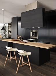 Notre sélection des plus belles cuisines. Chic Black Kitchen Countertops With Black Oven Hood And The Contrast Of White Low Profile Barstools House Interior Modern Kitchen Design Kitchen Design