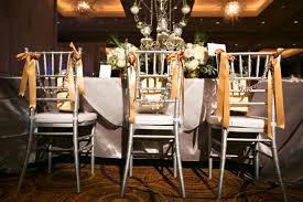 Silver Chiavari Chairs Adorned With Gold Grosgrain Ribbon And Draped In Crystal Beads Chiavari Weddingreception Silver Chiavari Chairs Venues Chiavari Chairs